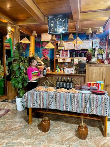 a woman standing behind a table in a store at Hiếu Hương Homestay in Lũng Tiềm