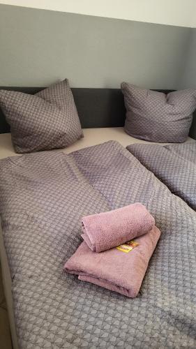 a bed with two pillows and two towels on it at Ferienbutzen Harz Flieder in Bad Lauterberg