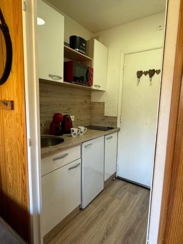 une petite cuisine avec un évier et un réfrigérateur dans l'établissement Studio au cœur d auron 118, à Saint-Étienne-de-Tinée