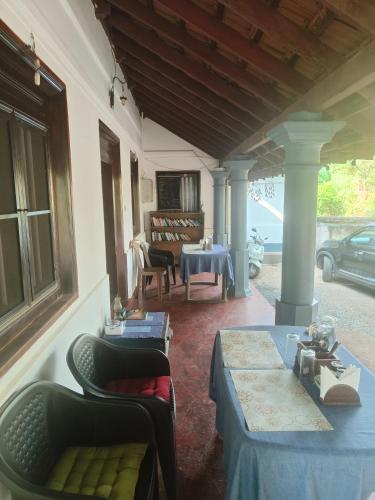 a living room with a table and chairs on a porch at Perch Next door in Kannur