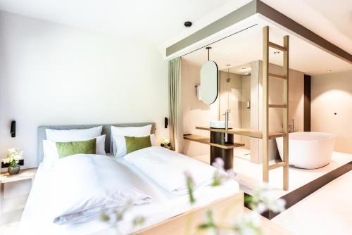 a bedroom with a bed and a bathroom at Hotel BERGEBLICK in Bad Tölz