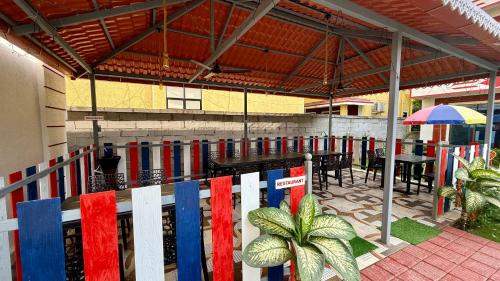 un patio con tavoli, sedie e un ombrellone di Coral Cove Resort, Nagaon a Nagaon