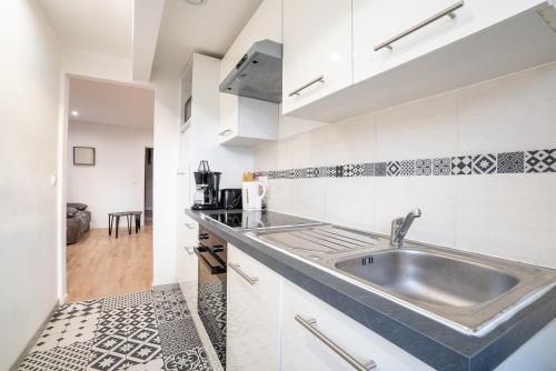 une cuisine avec un évier et un plan de travail dans l'établissement Budget apart downtown with parking, à Charleville-Mézières