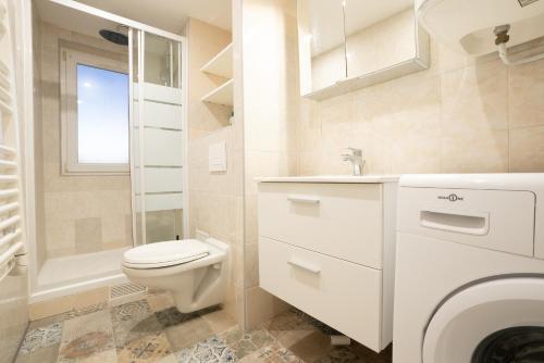 une salle de bain blanche avec des toilettes et un lavabo dans l'établissement Budget apart downtown with parking, à Charleville-Mézières