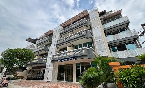 a large building with a sign in front of it at Charm Hostel at Pratumnak in Pattaya South