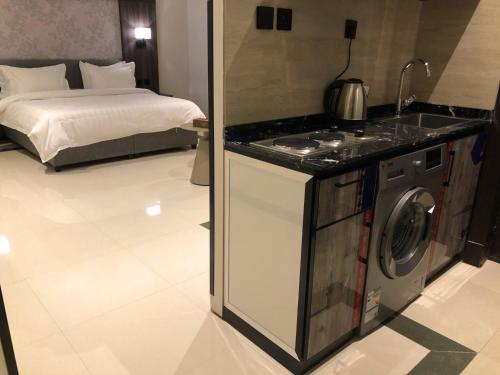 a kitchen with a washing machine next to a bed at شقق ثري ستار للشقق المخدومة in Riyadh