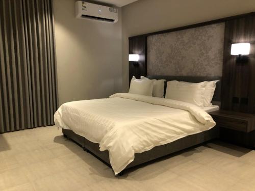 a bedroom with a large bed with white sheets and pillows at شقق ثري ستار للشقق المخدومة 4 in Riyadh