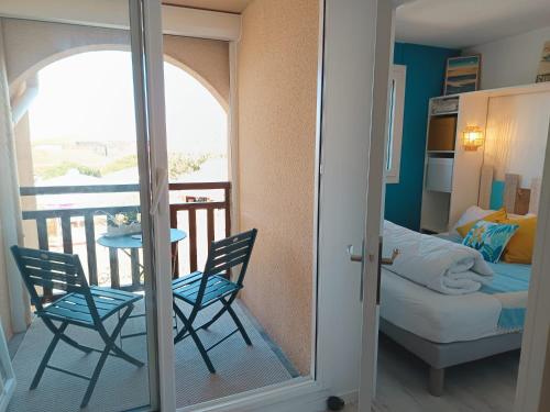 une chambre avec un balcon avec une table et des chaises dans l'établissement appartement T2 biscarosse plage, à Biscarrosse-Plage