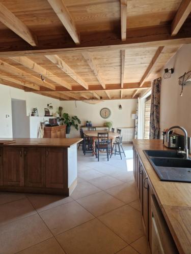 Il comprend une cuisine dotée de plafonds en bois et une salle à manger. dans l'établissement Mas Crudel - Maison de caractère, à Parisot
