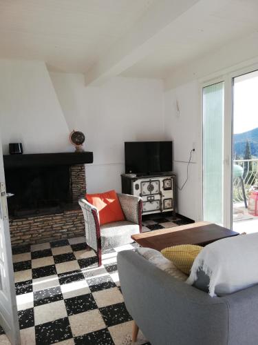 un salon avec un canapé et une cheminée dans l'établissement Maison vue Panoramique, à Vailhan