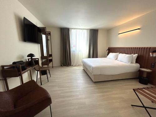 a hotel room with a bed and a desk at Adonis le Castellet in Signes