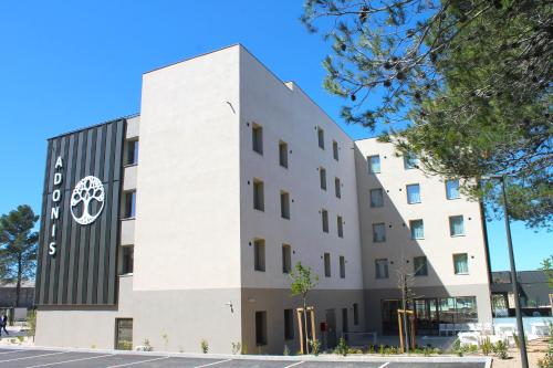 a building with a sign on the side of it at Adonis le Castellet in Signes