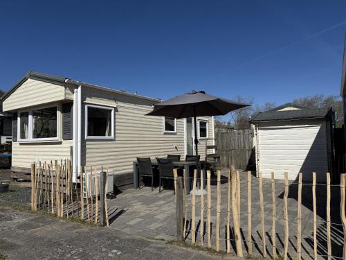 a house with a table and an umbrella at Duindoorn 46 in IJmuiden