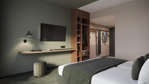 a bedroom with a bed and a tv on the wall at Holiday Inn - the niu, Flux Passau by IHG in Passau