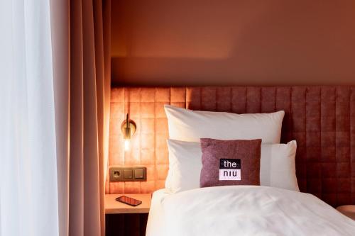 a bed with a pillow that reads the mcu at Holiday Inn - the niu, Flux Passau by IHG in Passau
