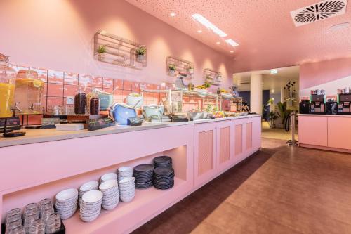 a restaurant with a counter with plates on it at Holiday Inn - the niu, Flux Passau by IHG in Passau