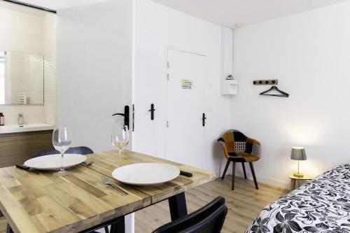 a dining room with a wooden table and chairs at Segré centre ? studio ? 24m² ? cuisne ? wifi ? TOUT NEUF! in Segré
