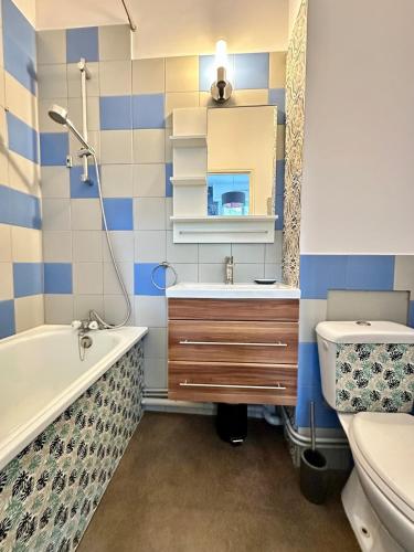 une salle de bain avec une baignoire, un lavabo et des toilettes dans l'établissement Appartement à 300m de la plage, à La Tremblade