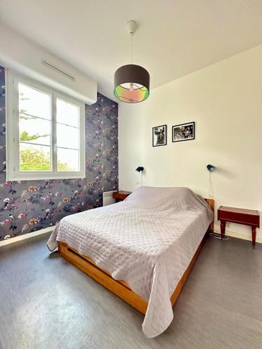 une chambre avec un grand lit et une fenêtre dans l'établissement Appartement à 300m de la plage, à La Tremblade