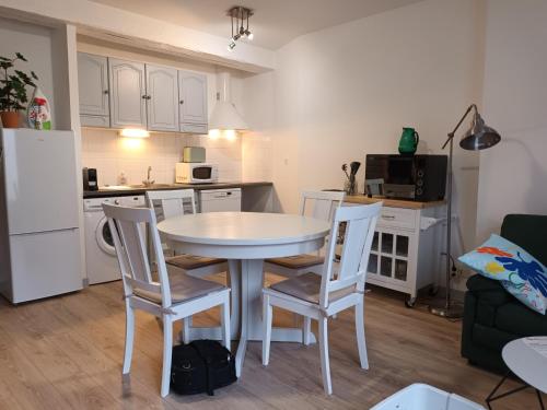 une cuisine et une salle à manger avec une table et des chaises dans l'établissement Duplex de Zola, à Segré