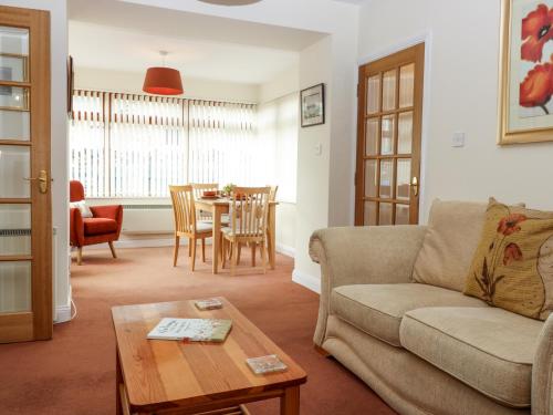 a living room with a couch and a table at Dromore Cottage in Berwick-Upon-Tweed