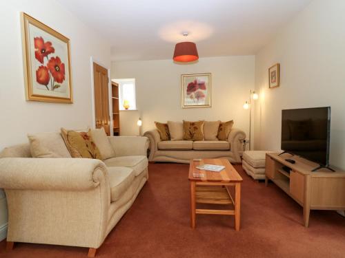 a living room with two couches and a flat screen tv at Dromore Cottage in Berwick-Upon-Tweed