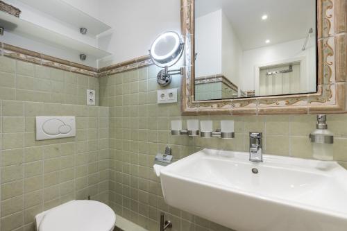 Un baño con lavabo, inodoro y espejo. en Haus Victoria, en Westerland