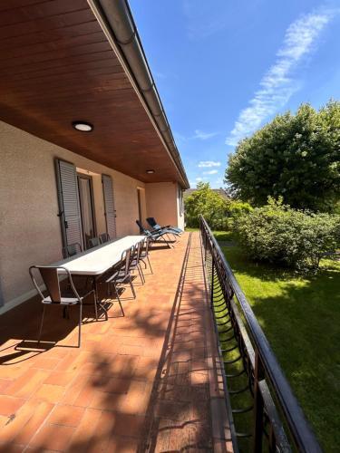 une terrasse avec des chaises et une table sur une maison dans l'établissement Splendide Villa, grand jardin à 2 pas du Golf, à Levernois