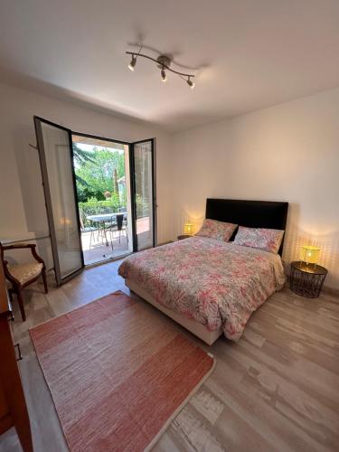une chambre avec un grand lit et un patio dans l'établissement Splendide Villa, grand jardin à 2 pas du Golf, à Levernois