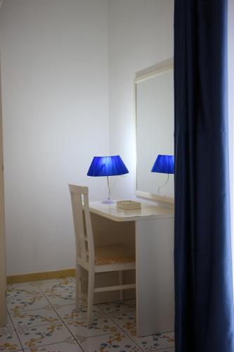 a desk with a chair and a blue lamp at Villa Loreta in Ischia