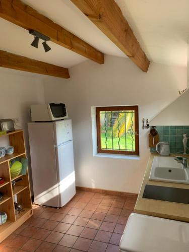 Il comprend une cuisine équipée d'un réfrigérateur et d'une fenêtre. dans l'établissement Les Muguets, à La Rochelle