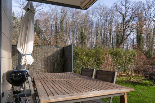 a wooden table and an umbrella on a patio at Les terrasses du Lavaux in Puidoux
