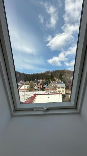 a window in a room with a view of a city at Villa Leopold - apartmánový dům in Karlovy Vary