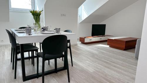 a dining room with a table and chairs and a tv at Villa Leopold - apartmánový dům in Karlovy Vary