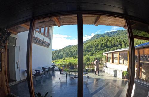 a man standing on a balcony with a view of a mountain at Ananda Resort in Paro