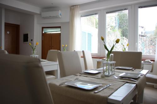 a dining room with a table and chairs and windows at Villa Loreta in Ischia