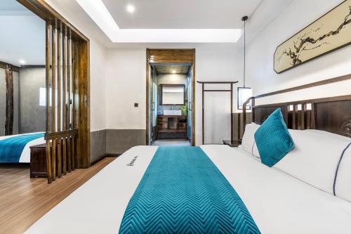 a hotel room with two beds and a hallway at Jiuqi Tongnian High-end River View B&B in Fenghuang