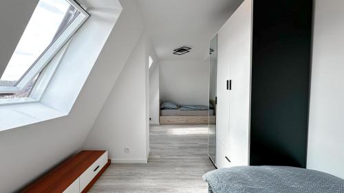 an attic bedroom with a hallway with a window at Villa Leopold - apartmánový dům in Karlovy Vary