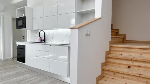 a kitchen with white cabinets and a staircase at Villa Leopold - apartmánový dům in Karlovy Vary