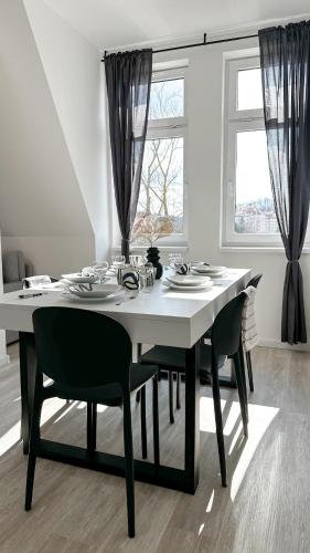 a dining room table with chairs and a large window at Villa Leopold - apartmánový dům in Karlovy Vary