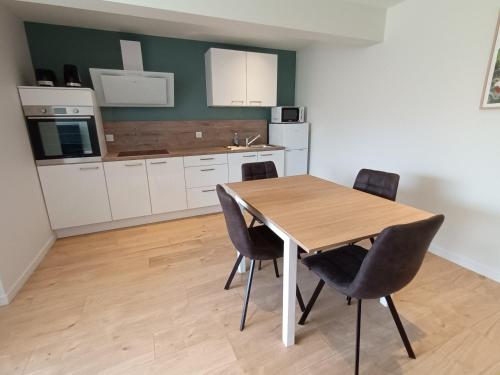 a kitchen with a wooden table and chairs at gîte du Cellier nantais in Le Cellier