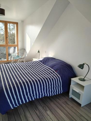 une chambre avec un lit avec une couverture rayée bleue et blanche dans l'établissement Ker Kast - Grande maison proche plage, à Saint-Cast-le-Guildo