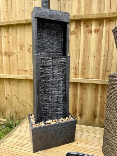 a black bird feeder sitting on top of a table at Acorn Lodge Pentewan in St Austell