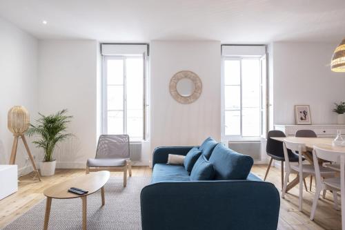 a living room with a blue couch and a table at grand gîte terrasse vue Loire et château d'Ancenis in Ancenis