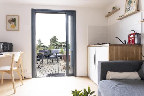 a living room with a door leading to a patio at petit Gîte T2 des balcons d'Ancenis in Ancenis