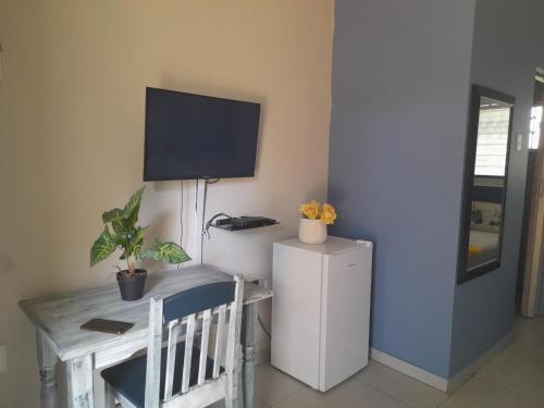 a room with a desk and a tv on the wall at The Rose Guesthouse in Witbank