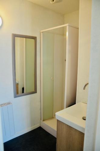 une salle de bain avec un lavabo et un miroir dans l'établissement à quelques pas de la plage, à Longeville-sur-Mer