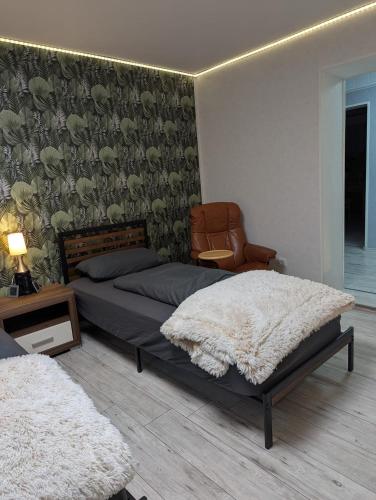 una camera con due letti e una sedia di Wohnung "Anna" a Stadtallendorf