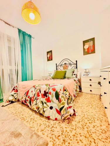 a bedroom with a bed with a floral bedspread at House in the heart of Dos Hermanas in Dos Hermanas