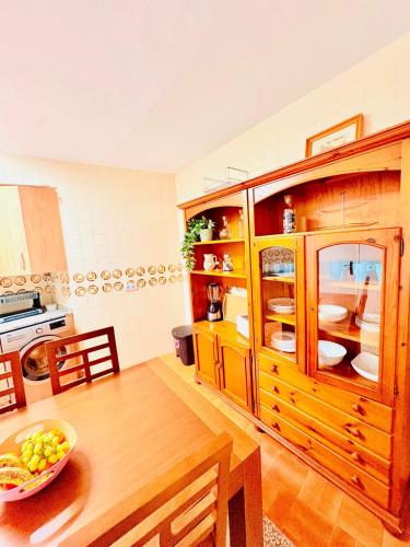 a kitchen with a table and a large wooden cabinet at House in the heart of Dos Hermanas in Dos Hermanas